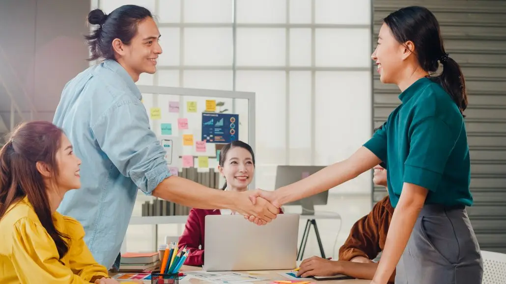 Multiracial Group Young Creative People Smart Casual Wear Discussing Business Shaking Hands Together Smiling While Standing Modern Office Partner Cooperation Coworker Teamwork Concept 1030x579